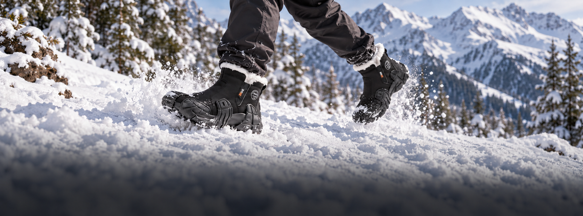 Black RIDGEWARD fur-lined boots moving through snow with mountain peaks in the background